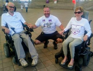 Two people living with ALS posing with WALK for ALS participant and friend